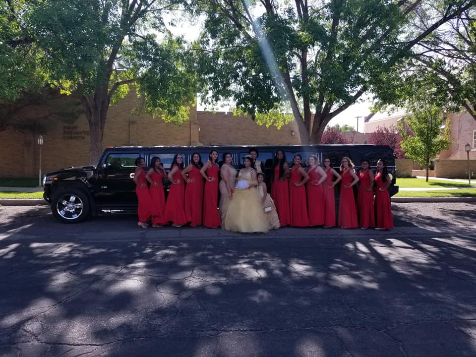 Quinceañera and court in red dresses outside the church