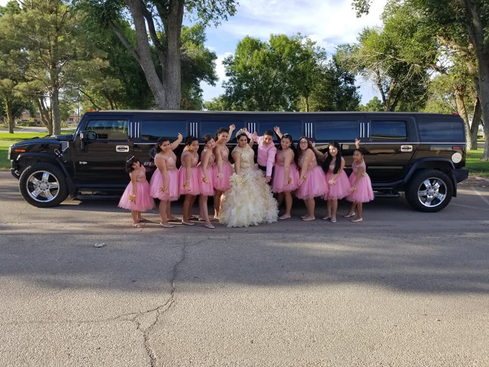 Quinceañera court in pink dresses celebrating with the Hummer